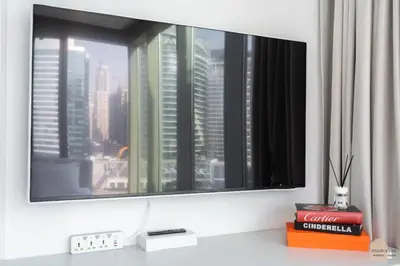 a television on top of a desk with a window at Réveille Face au Burj Khalifa Vu Canal & Piscine in Dubai