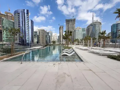 a swimming pool in a city with tall buildings at Réveille Face au Burj Khalifa Vu Canal & Piscine in Dubai