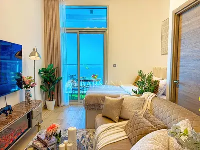 a living room with a couch and a view of the ocean at Barsana - Seabreeze Suite - 2 Bed - Sea Views in Dubai