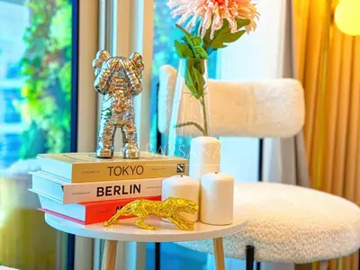 a pile of books on a table next to a chair at Barsana - Seabreeze Suite - 2 Bed - Sea Views in Dubai