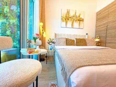 a bedroom with two beds and a table with flowers at Barsana - Seabreeze Suite - 2 Bed - Sea Views in Dubai