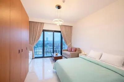 a bedroom with a bed and a couch and a window at City Glow Comfort Studio - Oasis Pool in Dubai