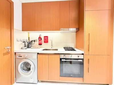 a kitchen with a sink and a washing machine at City Glow Comfort Studio - Oasis Pool in Dubai