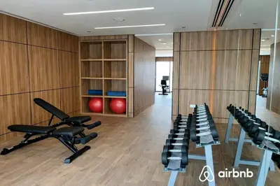 a gym with treadmills and exercise bikes in a room at City Glow Comfort Studio - Oasis Pool in Dubai