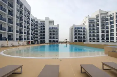 an empty pool in the middle of two apartment buildings at City Glow Comfort Studio - Oasis Pool in Dubai