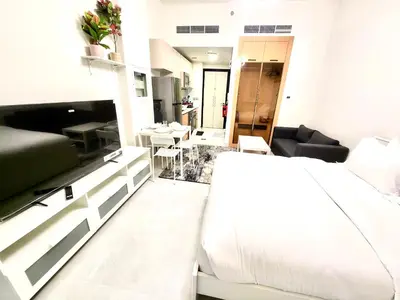 a bedroom with a bed and a living room at Brand new Studio in Skyz by Danube Arjan in Dubai