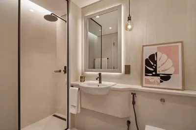 a white bathroom with a sink and a mirror at Sky-high luxury in DIFC I new and modern in Dubai