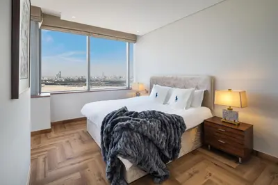 a bedroom with a bed and a large window at Sky-high luxury in DIFC I new and modern in Dubai
