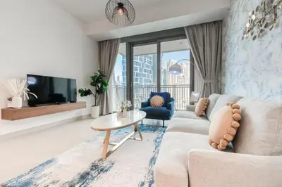 a living room with a couch and a tv at Luxury Sea View 1BR in JBR with easy Bluewaters Access in Dubai