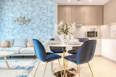 a kitchen and living room with a table and chairs at Luxury Sea View 1BR in JBR with easy Bluewaters Access in Dubai