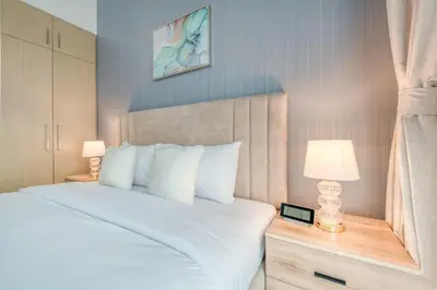 a bedroom with a large white bed with two lamps at Luxury Sea View 1BR in JBR with easy Bluewaters Access in Dubai