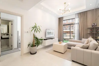 a white living room with a couch and a tv at Luxury 1BR Apartment in Binghatti Mirage JVC Dubai in Dubai