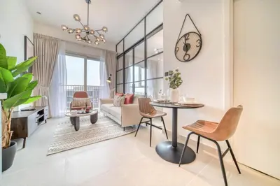 a living room with a table and a clock on the wall at Stunning 1 B R in Dubai Hills in Dubai