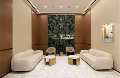 a lobby with two white couches and two tables at Amazing Amenities Studio JVC Gym Near Mall in Dubai