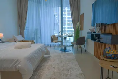 a bedroom with a bed and a table and chairs at Amazing Amenities Studio JVC Gym Near Mall in Dubai