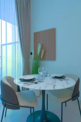 a white table with two chairs and a table with wine glasses at Amazing Amenities Studio JVC Gym Near Mall in Dubai