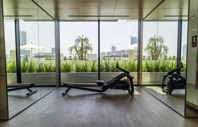 a gym with two exercise bikes in a room with windows at Amazing Amenities Studio JVC Gym Near Mall in Dubai