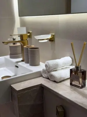 a bathroom with a sink and towels on a counter at Stylish 2Bedroom JVC I Comfort I Epic Pool in Dubai
