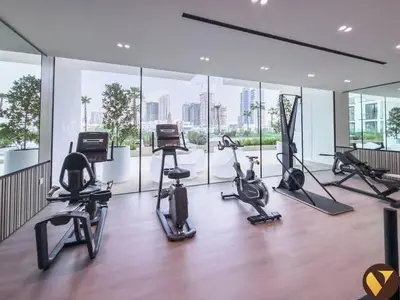 a gym with several exercise bikes in a room with windows at Stylish 2Bedroom JVC I Comfort I Epic Pool in Dubai