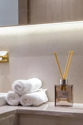 a bathroom counter with towels and a bottle of perfume at Cozy JVC Studio I Pool & Gym I Fully Furnished in Dubai