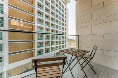 a table and chairs on a balcony with a building at Tranquil Studio Just minutes Drive to Dubai Attraction, O10 Building Al Jaddaf by Deluxe Holiday Homes in Dubai