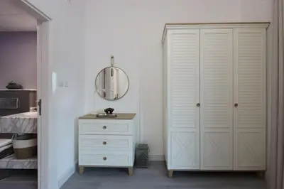 a bedroom with a white closet and a dresser at Casa Aruri,1B Marina Escape Near Metro and Marina Mall in Dubai