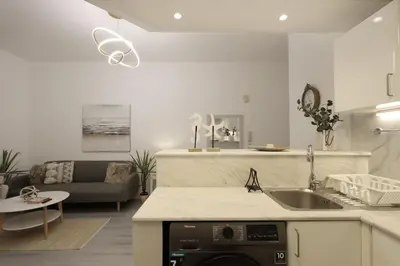 a kitchen with a sink and a living room at Casa Aruri,1B Marina Escape Near Metro and Marina Mall in Dubai
