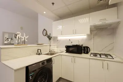 a kitchen with white cabinets and a dishwasher at Casa Aruri,1B Marina Escape Near Metro and Marina Mall in Dubai