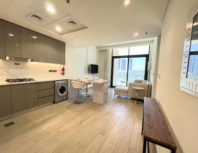 a large kitchen with a table and a counter at Chic French-Riviera Vibe - Burj View 1BR in Dubai