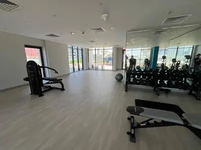 a gym with tread machines and people in the background at Chic French-Riviera Vibe - Burj View 1BR in Dubai