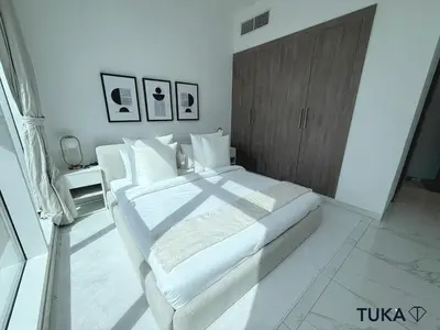 a white bedroom with a large bed and a wooden cabinet at 1-BHK - Brand New Building - Spacious - Central in Dubai