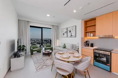 a kitchen and living room with a table and chairs at Escape24 Elegant 1BR with Community Views in Dubai Hills Estate in Dubai
