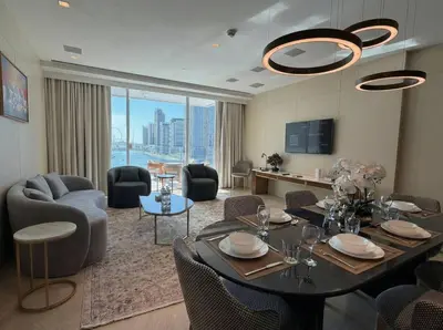 a dining room with a table and chairs and a living room at FIVE Palm | Stunning Sea-View Luxury 2BR Apartment in Dubai