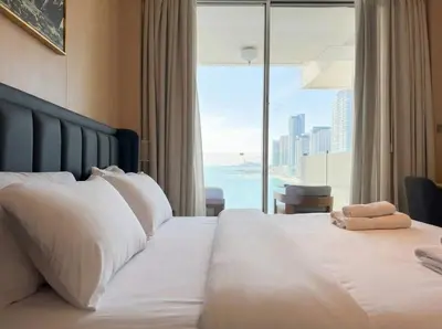 a bedroom with a large white bed with a large window at FIVE Palm | Stunning Sea-View Luxury 2BR Apartment in Dubai