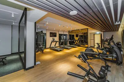 a gym with several treadmills and cardio machines at 1BR Burj View Apartment In Dubai Creek Harbour in Dubai