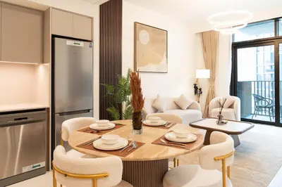 a kitchen and living room with a table and chairs at 1BR Burj View Apartment In Dubai Creek Harbour in Dubai