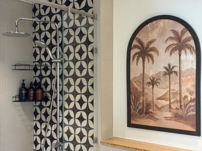 a shower in a bathroom with a mural of palm trees at Smart & Elegant 2BR in Collective Dubai Hills in Dubai