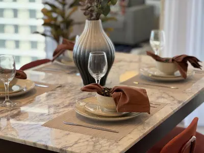 a table with plates of food and wine glasses at Smart & Elegant 2BR in Collective Dubai Hills in Dubai