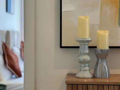 two candles in a glass vase on a table at Smart & Elegant 2BR in Collective Dubai Hills in Dubai