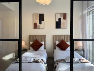 a room with two beds and a mirror at Smart & Elegant 2BR in Collective Dubai Hills in Dubai
