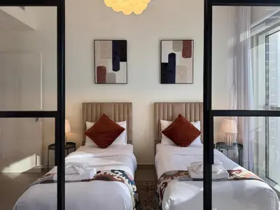 a bedroom with two beds and a mirror at Smart & Elegant 2BR in Collective Dubai Hills in Dubai