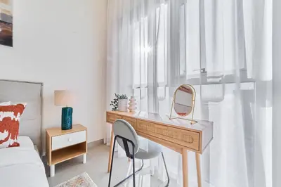 a bedroom with a desk with a mirror and a bed at Smart & Elegant 2BR in Collective Dubai Hills in Dubai