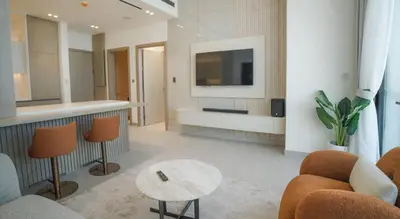 a living room with a tv and a couch and a table at Premium 1BR in JVC with Private Pool in Dubai