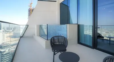 a balcony with a chair and a view of the city at Premium 1BR in JVC with Private Pool in Dubai