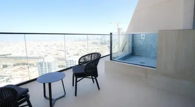 a balcony with chairs and a table and a view at Premium 1BR in JVC with Private Pool in Dubai