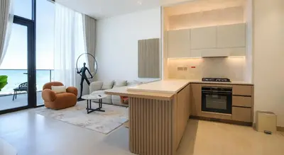 a kitchen with a counter and a table in a room at Premium 1BR in JVC with Private Pool in Dubai