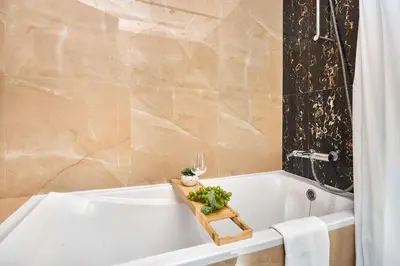 a bathroom with a white bath tub with a glass of wine at Frank Porter - Elite Downtown Residence 1 in Dubai