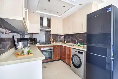 a kitchen with white cabinets and a washer and dryer at Frank Porter - Elite Downtown Residence 1 in Dubai