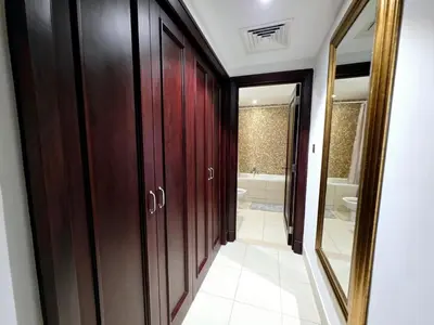 a bathroom with wooden cabinets and a mirror at Yansoon 3 Downtown, Dubai in Dubai