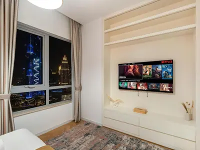 a bedroom with a flat screen tv on a wall at BurjKhalifa l Live show fountain view 3BR Downtown in Dubai